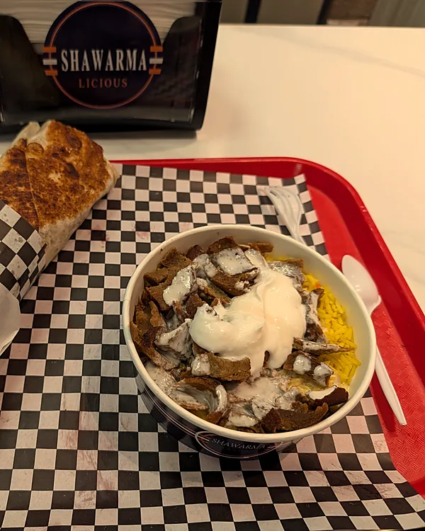 Donair rice bowl and a wrap on a red tray, with the Shawarmalicious napkin holder