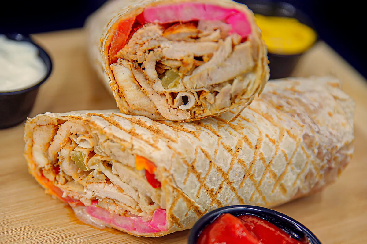 Chicken shawarma wrap cut in half, with pickled turnip